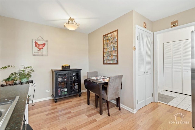 dining area with baseboards and light wood-style floors