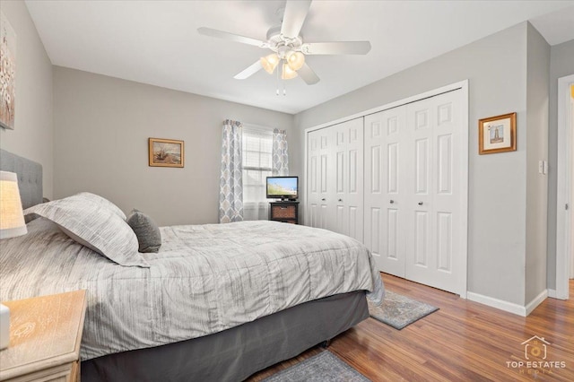 bedroom featuring a closet, a ceiling fan, baseboards, and wood finished floors