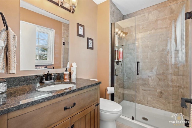 full bathroom featuring vanity, toilet, and a stall shower