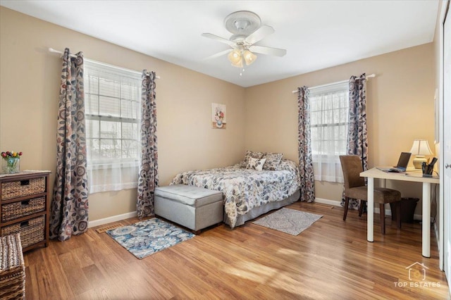 bedroom with ceiling fan, baseboards, and wood finished floors