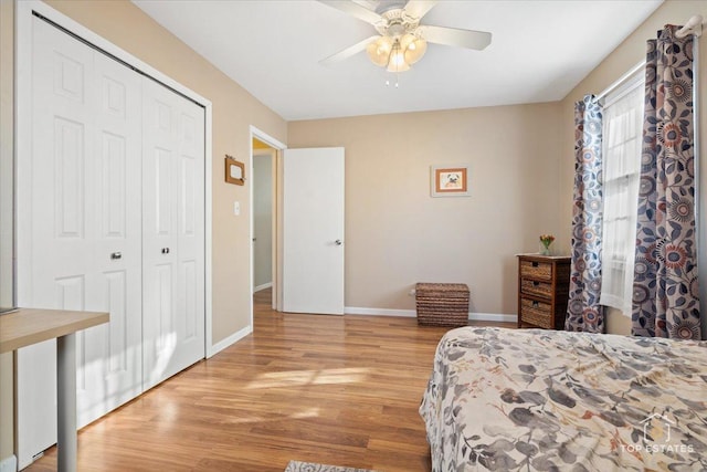 bedroom with a closet, light wood-style flooring, baseboards, and ceiling fan