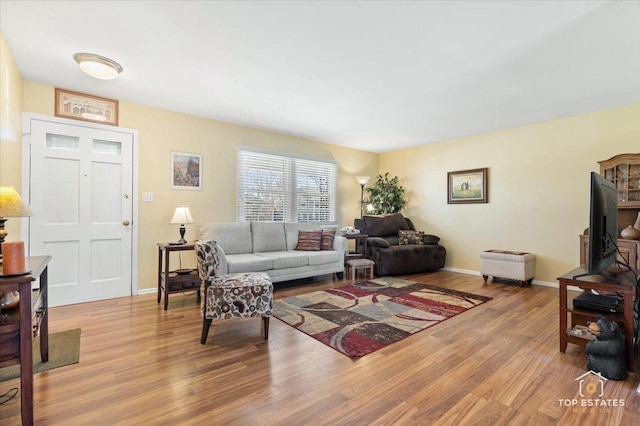 living area with baseboards and wood finished floors