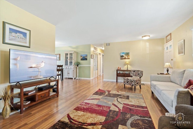 living area featuring baseboards and wood finished floors