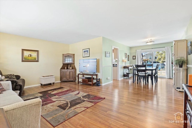 living room with baseboards and light wood-type flooring