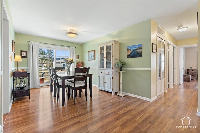 dining space with wood finished floors and baseboards