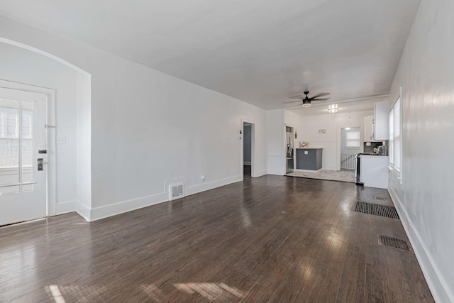 unfurnished living room with ceiling fan, dark wood-type flooring, and visible vents