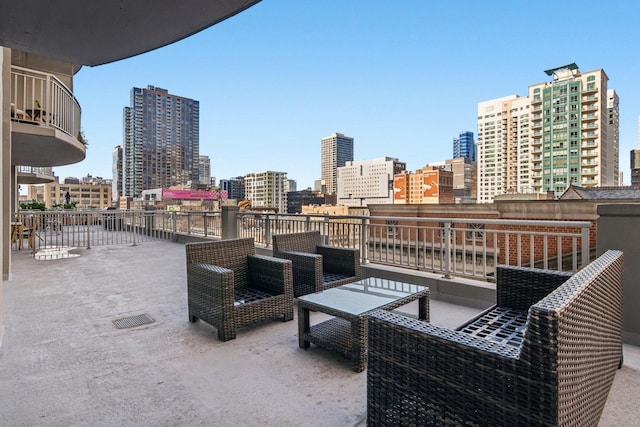 view of patio / terrace with a balcony, an outdoor hangout area, and a city view