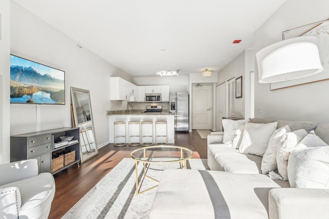 living area featuring dark wood-style floors and baseboards