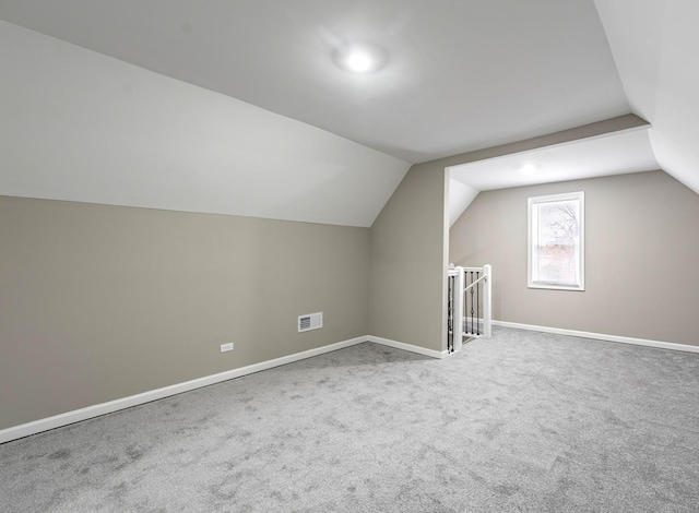 bonus room with lofted ceiling, carpet, visible vents, and baseboards