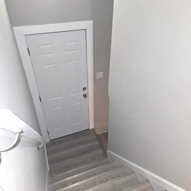 staircase with wood finished floors and baseboards