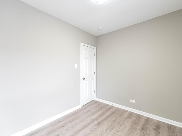 spare room featuring light wood-type flooring and baseboards