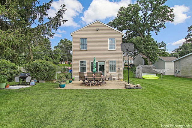 back of property featuring a yard, a patio, an outdoor structure, and a storage unit