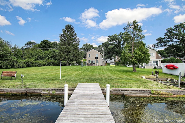 dock area with a water view and a yard