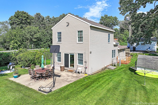 back of house with a patio area and a lawn