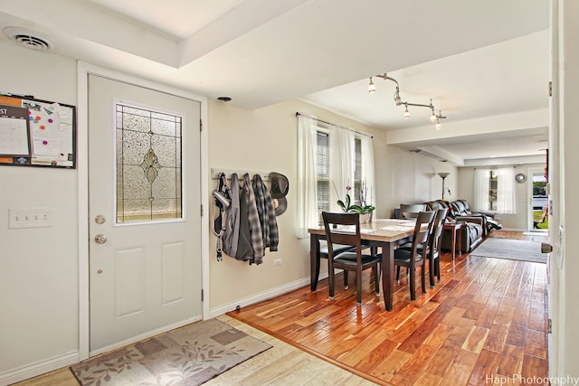 dining area with light wood-style floors, a wealth of natural light, visible vents, and baseboards