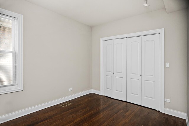 8837 S Throop St, Chicago, IL 60620 - unfurnished bedroom featuring dark wood-type flooring, baseboards, and a closet