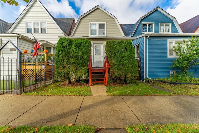 dutch colonial featuring a shingled roof, fence, and a gambrel roof