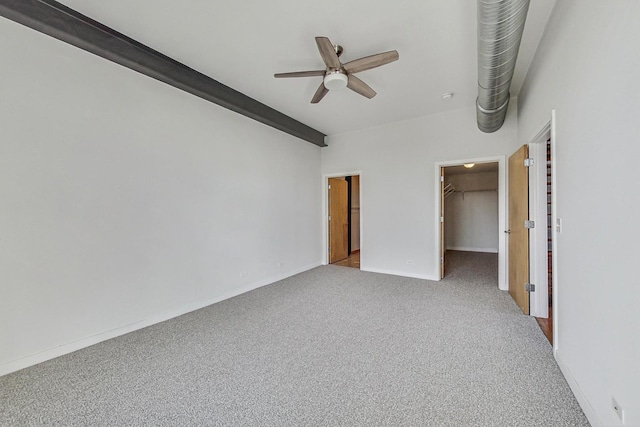 unfurnished bedroom with carpet floors, a closet, a spacious closet, ceiling fan, and baseboards