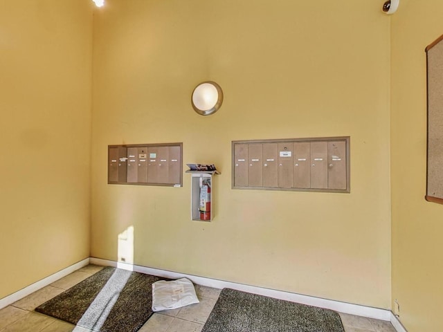 interior space featuring baseboards, mail area, and tile patterned floors