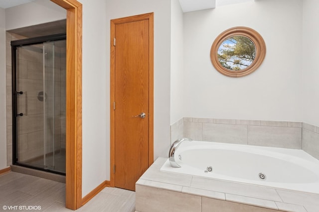 bathroom with a jetted tub, baseboards, and a stall shower