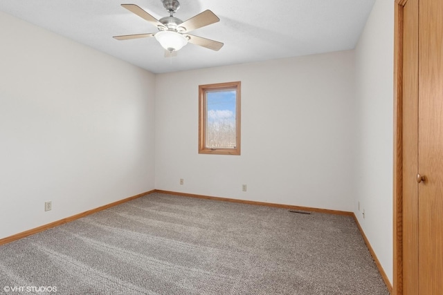 empty room featuring ceiling fan, visible vents, baseboards, and light carpet