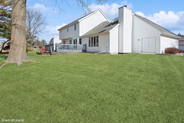 back of property with a yard and a chimney