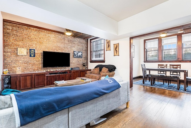 living room featuring brick wall and hardwood / wood-style floors