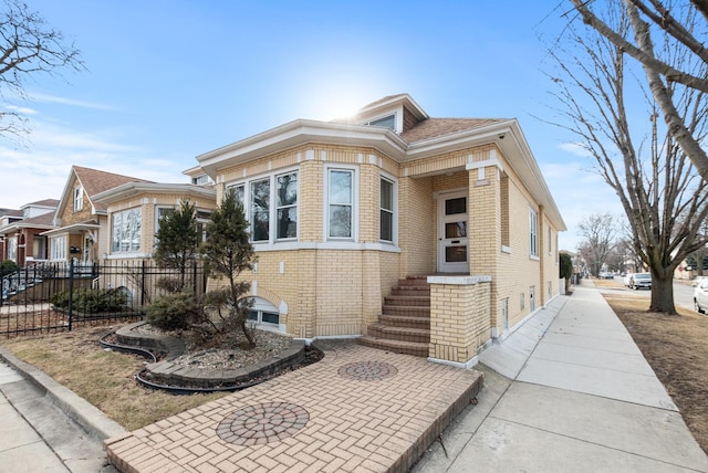 view of front of home featuring brick siding and fence