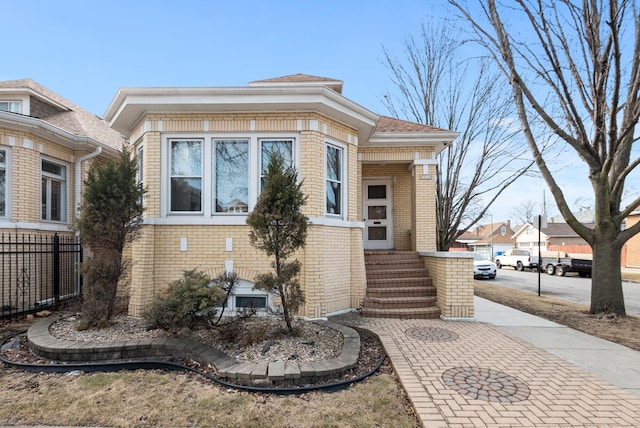 view of side of home featuring fence and brick siding