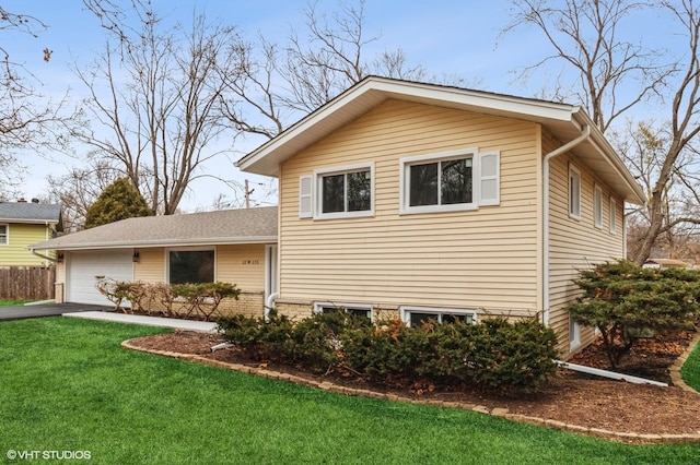 view of front facade featuring a garage, a front lawn, and aphalt driveway