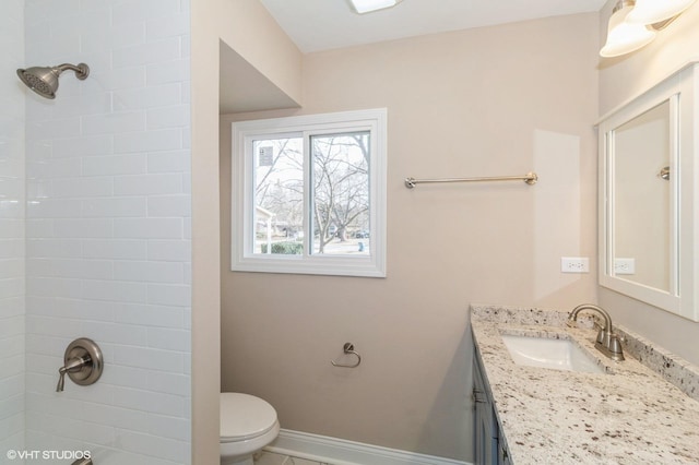 full bath featuring a shower, vanity, toilet, and baseboards