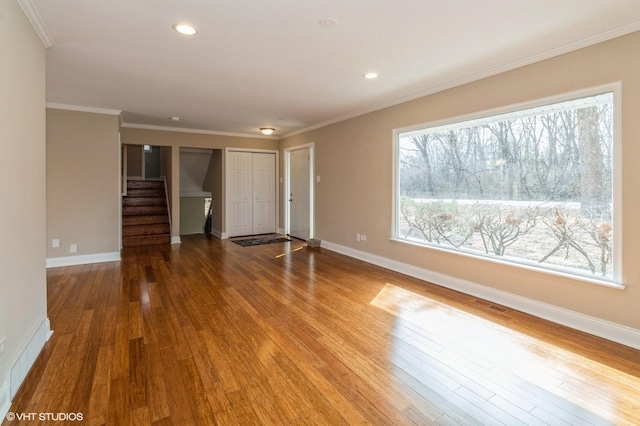 interior space with crown molding, recessed lighting, wood-type flooring, baseboards, and stairs