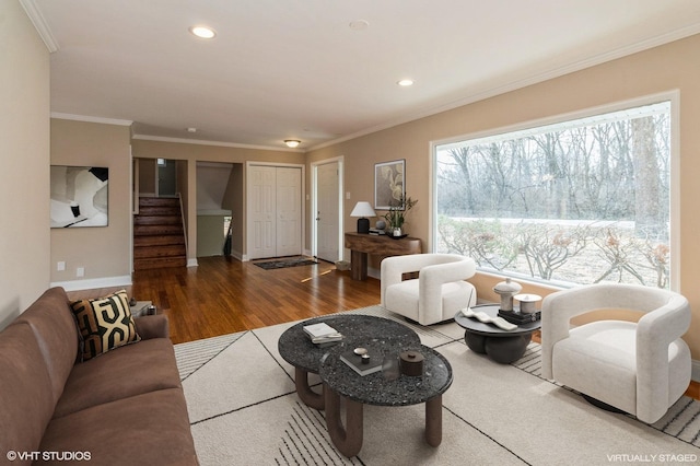 living area featuring baseboards, stairway, wood finished floors, crown molding, and recessed lighting