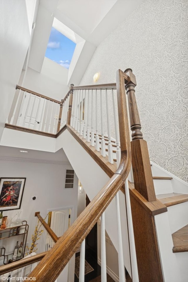 stairway featuring a towering ceiling