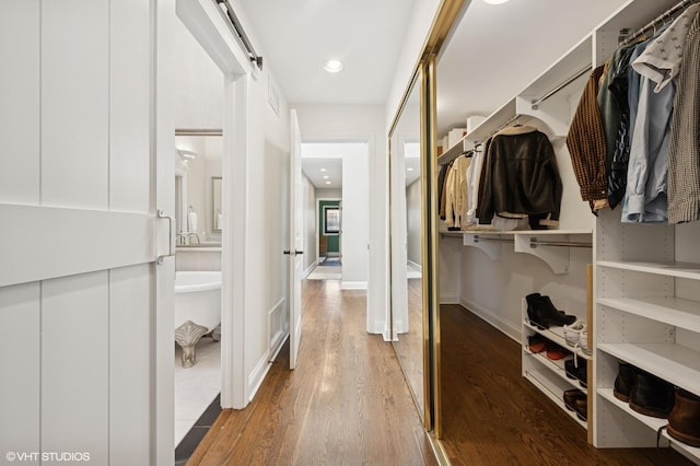 walk in closet with wood finished floors