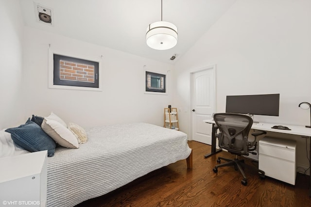 bedroom with dark wood finished floors and lofted ceiling