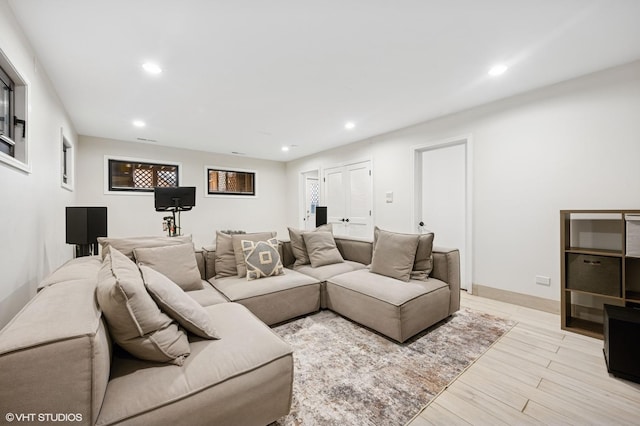 living room featuring recessed lighting, baseboards, and light wood finished floors