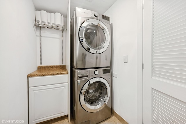 washroom with cabinet space and stacked washing maching and dryer