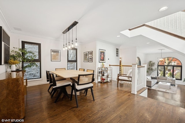 dining space with wood finished floors, a skylight, recessed lighting, crown molding, and a chandelier