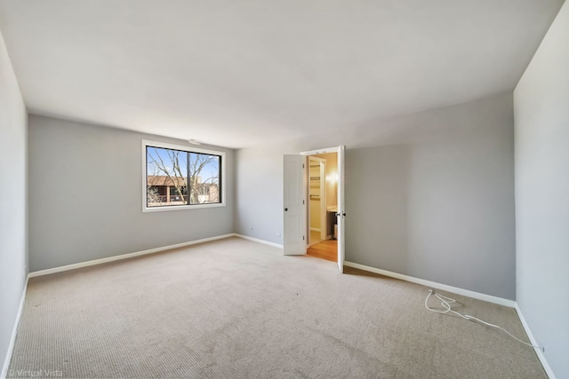 empty room featuring baseboards and carpet floors