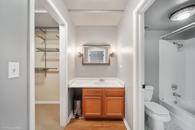 bathroom with baseboards, toilet, shower / washtub combination, and vanity