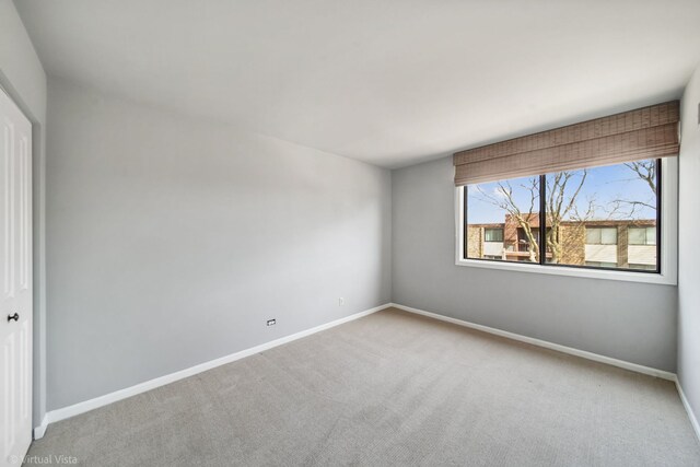 empty room with carpet and baseboards