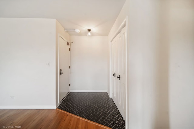 hall featuring baseboards and wood finished floors