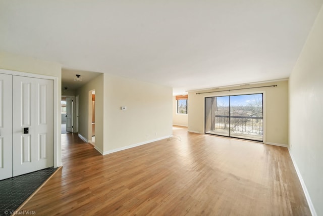 unfurnished room featuring baseboards and light wood finished floors