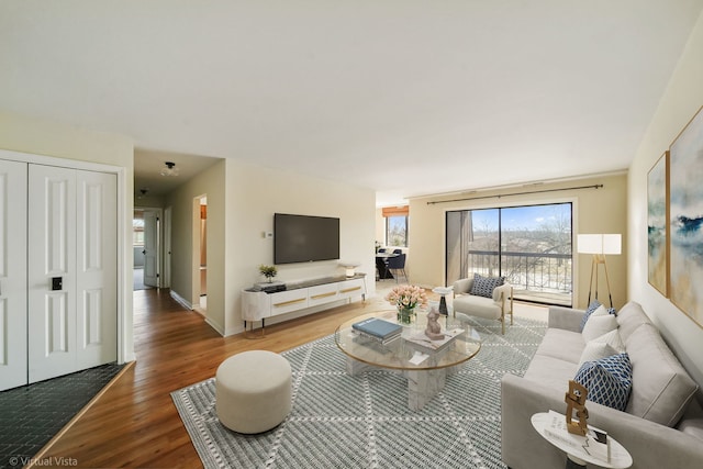 living area with baseboards and wood finished floors