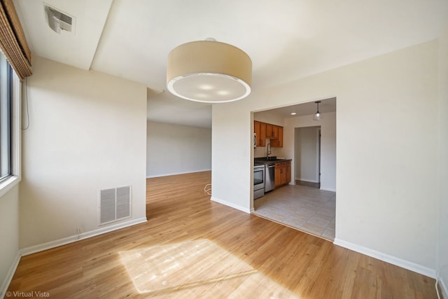 interior space featuring visible vents, baseboards, and light wood-style flooring