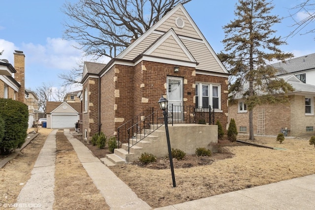 view of front of property featuring an outbuilding, brick siding, and a detached garage