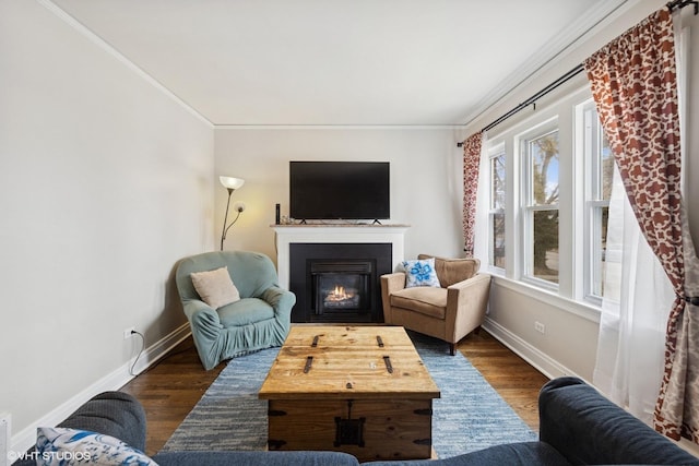 interior space featuring ornamental molding, dark wood finished floors, a lit fireplace, and baseboards