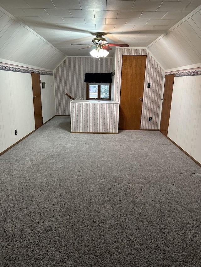 additional living space with vaulted ceiling, carpet, and a ceiling fan