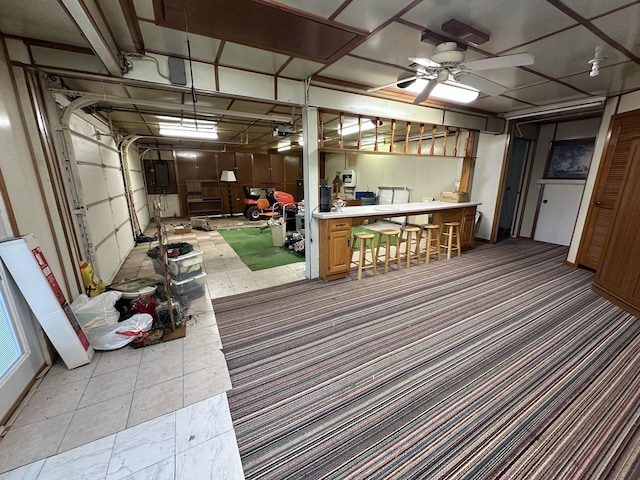 interior space with a garage and a ceiling fan